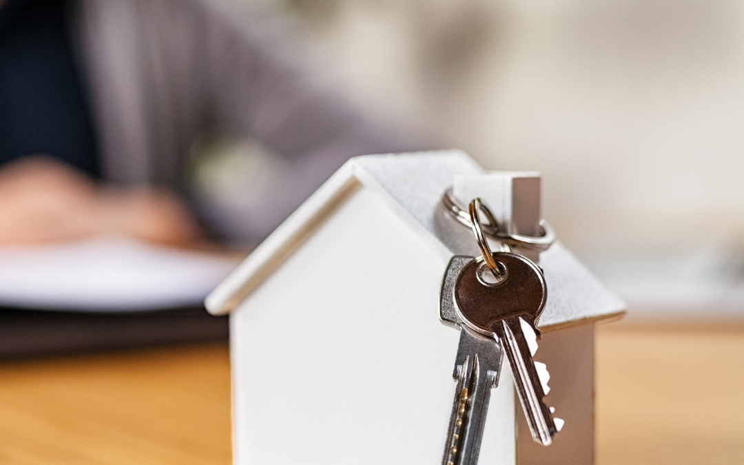 Image of a small white house with keys hanging from the chimney, symbolizing homeownership and entry into the housing market.